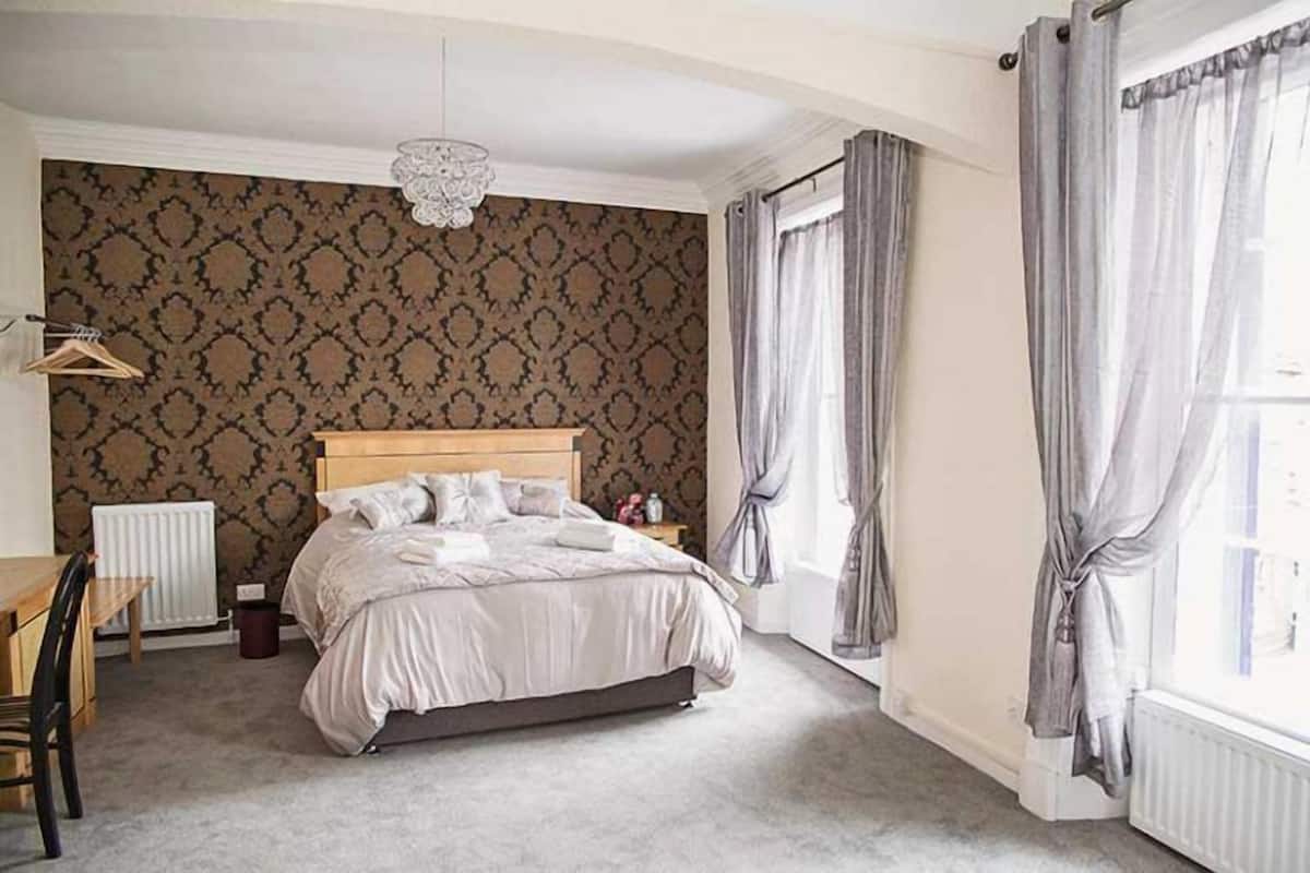 Um quarto com uma cama, uma escrivaninha e um radiador.