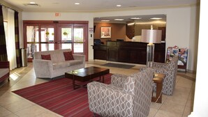 A hotel lobby with a reception desk, seating area, and a red carpet. - Spark by Hilton Rahway (Rahway)