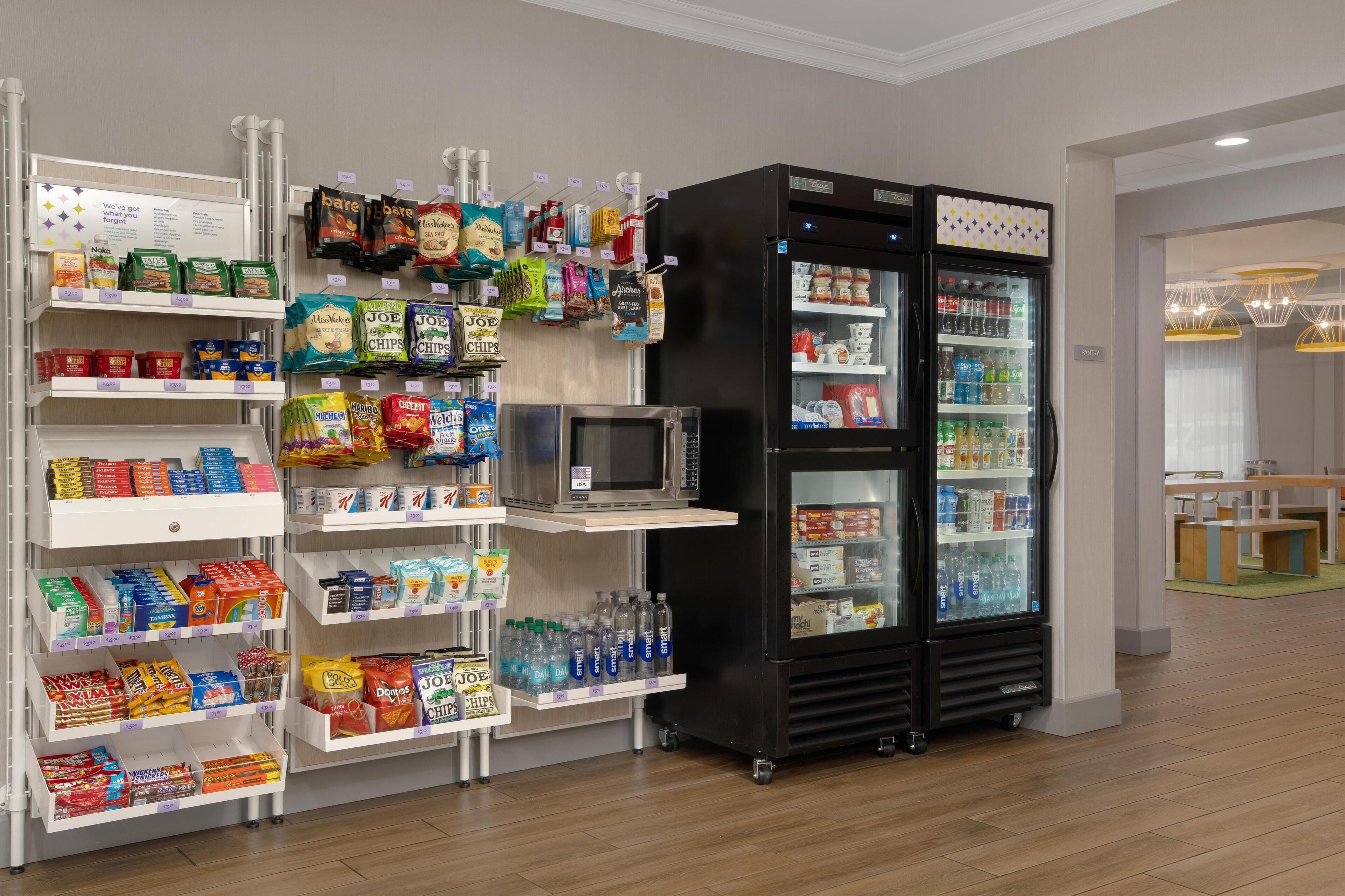 Area espositiva con snack e bevande, dotata di forno a microonde e frigorifero.