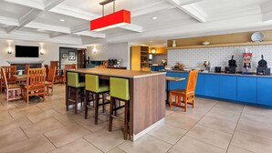 A modern kitchen with a central island, blue cabinets, and a variety of kitchen appliances. - Country Inn & Suites by Radisson, Portage, IN (Portage)