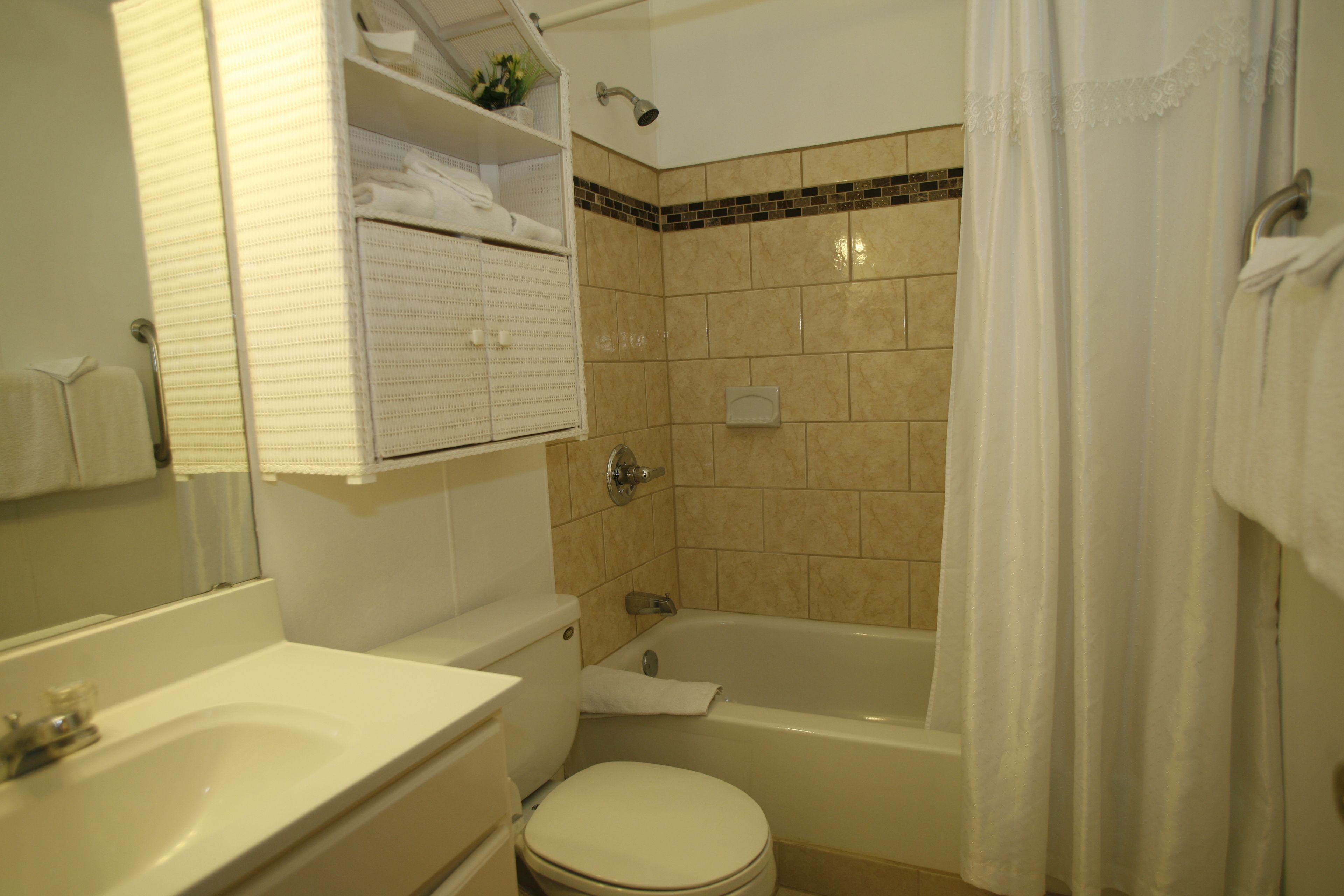 A bathroom with a toilet, sink, and bathtub.