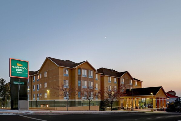 Un hôtel à plusieurs étages, avec une enseigne indiquant « Homewood Suites Hilton ».