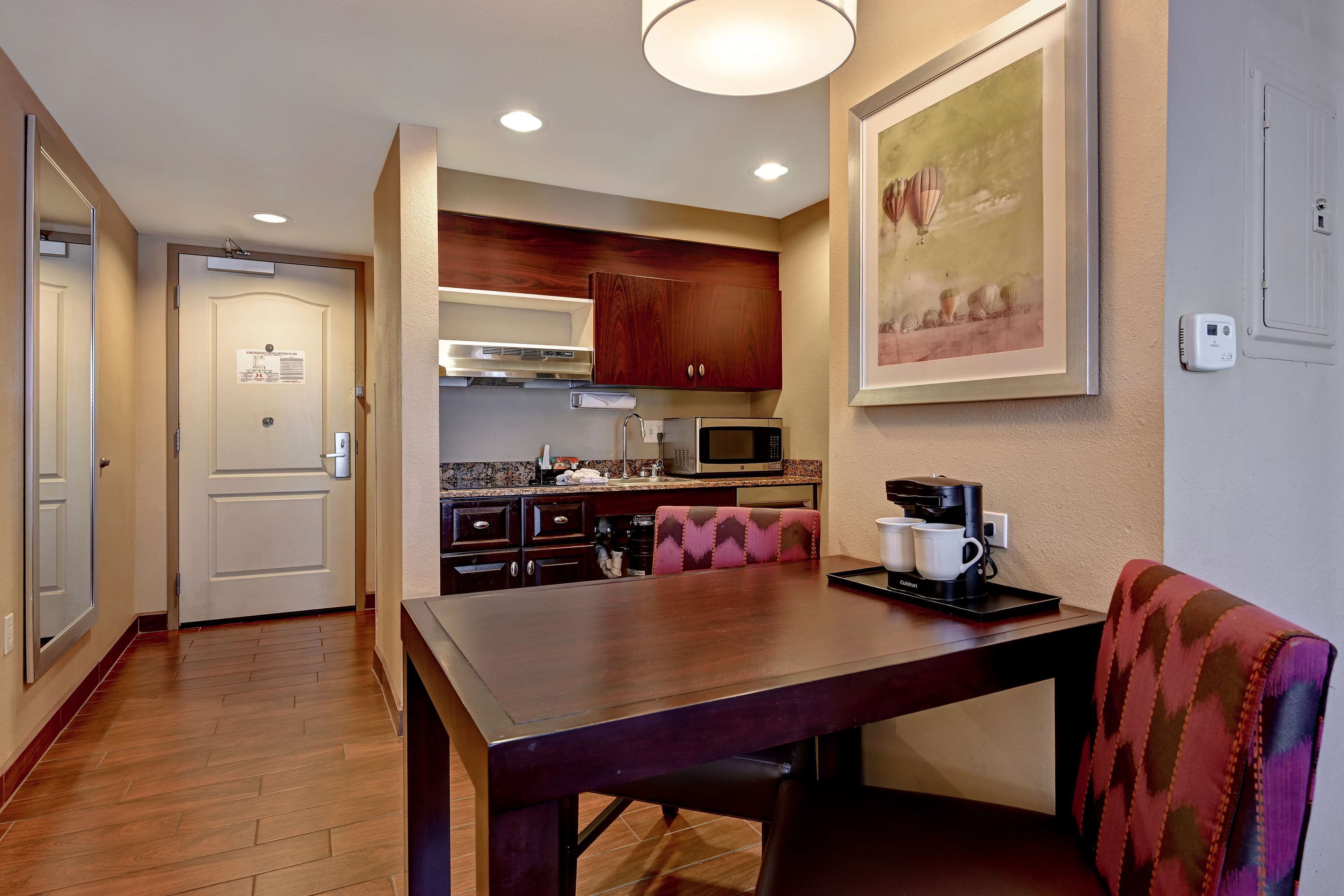 A modern kitchen with wooden cabinets, a microwave, and a coffee maker on the counter.