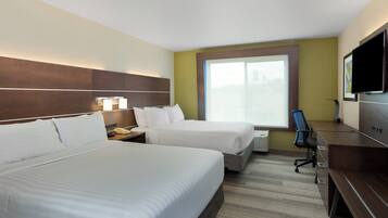 A hotel room with two beds, a desk, a chair, a TV, and a window with a view.
