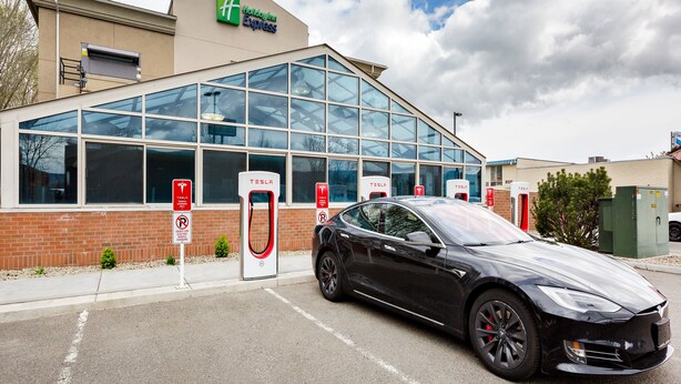 A Tesla charging station in front of a Holiday Inn Express hotel.