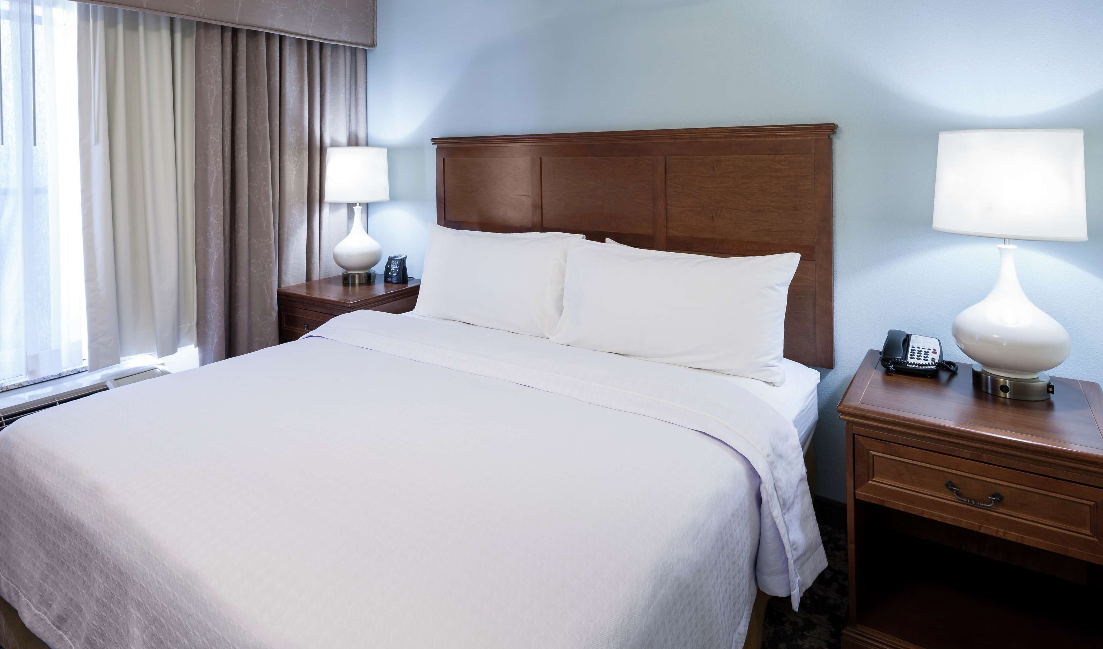 Premium bedding, desk, laptop workspace, blackout drapes