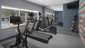 Une salle de sport moderne équipée de vélos d’appartement, de tapis de course et de ballons d’exercice.