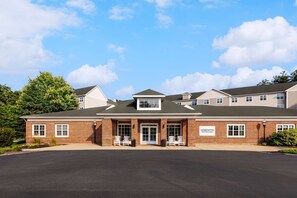 Welcome to Homewood Suites, a charming two-story building with a central entrance and beautifully manicured lawn.