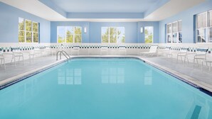 A swimming pool with clear blue water, surrounded by white chairs and a tiled deck. - Homewood Suites by Hilton Portsmouth (Portsmouth)