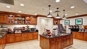 A spacious kitchen with wooden cabinets, a central island, and various appliances. - Homewood Suites by Hilton Bentonville-Rogers (Rogers)