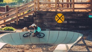 A person riding a bicycle on a ramp with a railroad crossing sign in the background. - Homewood Suites by Hilton Bentonville-Rogers (Rogers)