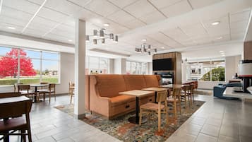 A modern interior with a sofa, tables, chairs, and a television.