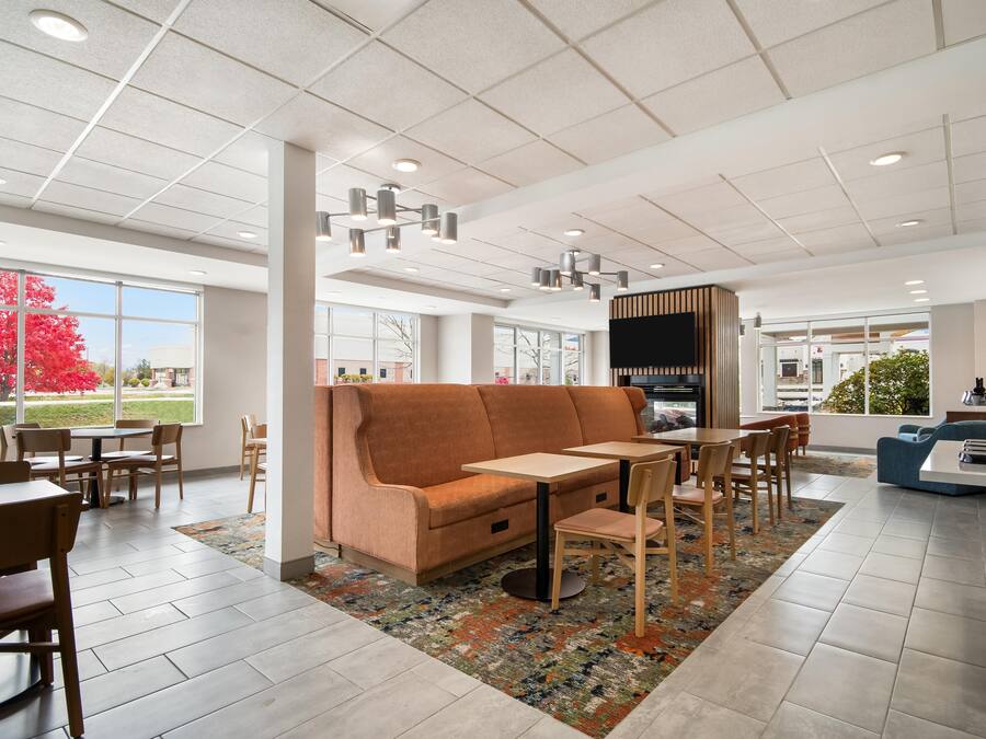 A modern interior with a sofa, tables, chairs, and a television.