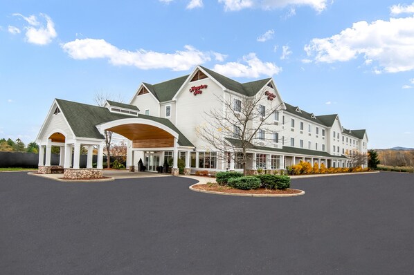 A large, white hotel with a prominent entrance and multiple wings.