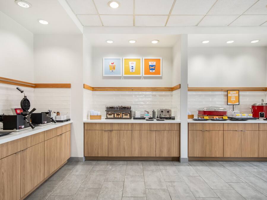 A modern kitchen with wooden cabinets, a coffee machine, and a toaster.