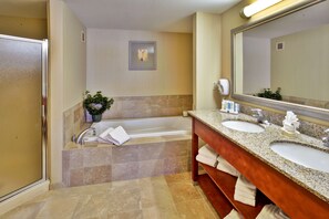Bathroom features a large bathtub, separate shower area, double sink vanity, and a mirror.