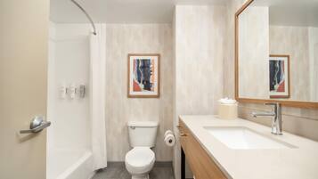 A modern bathroom with a bathtub, toilet, and sink.