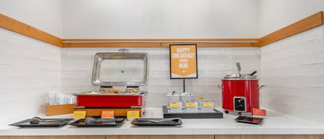 A breakfast buffet with labeled food stations including omelets, turkey sausage links, and redskin potatoes.