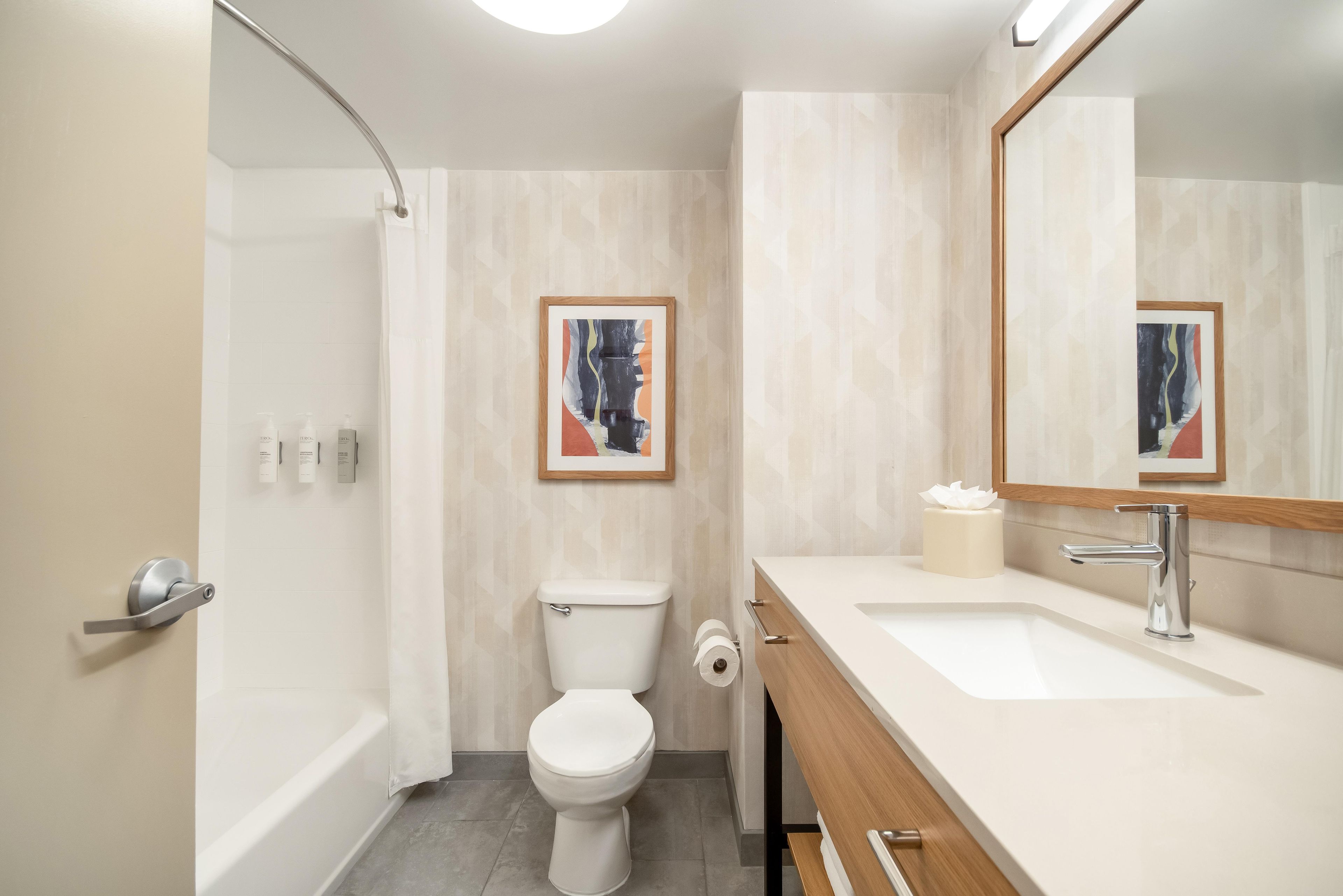 A modern bathroom with a toilet, sink, and shower.