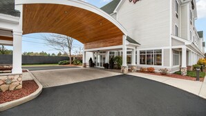 A hotel entrance with a covered walkway, stone pillars, and a sign reading "Haywood Inn."