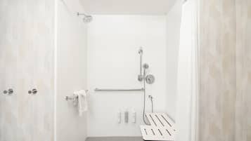 A modern shower with a handheld showerhead, a handheld shower attachment, and a wall-mounted faucet.