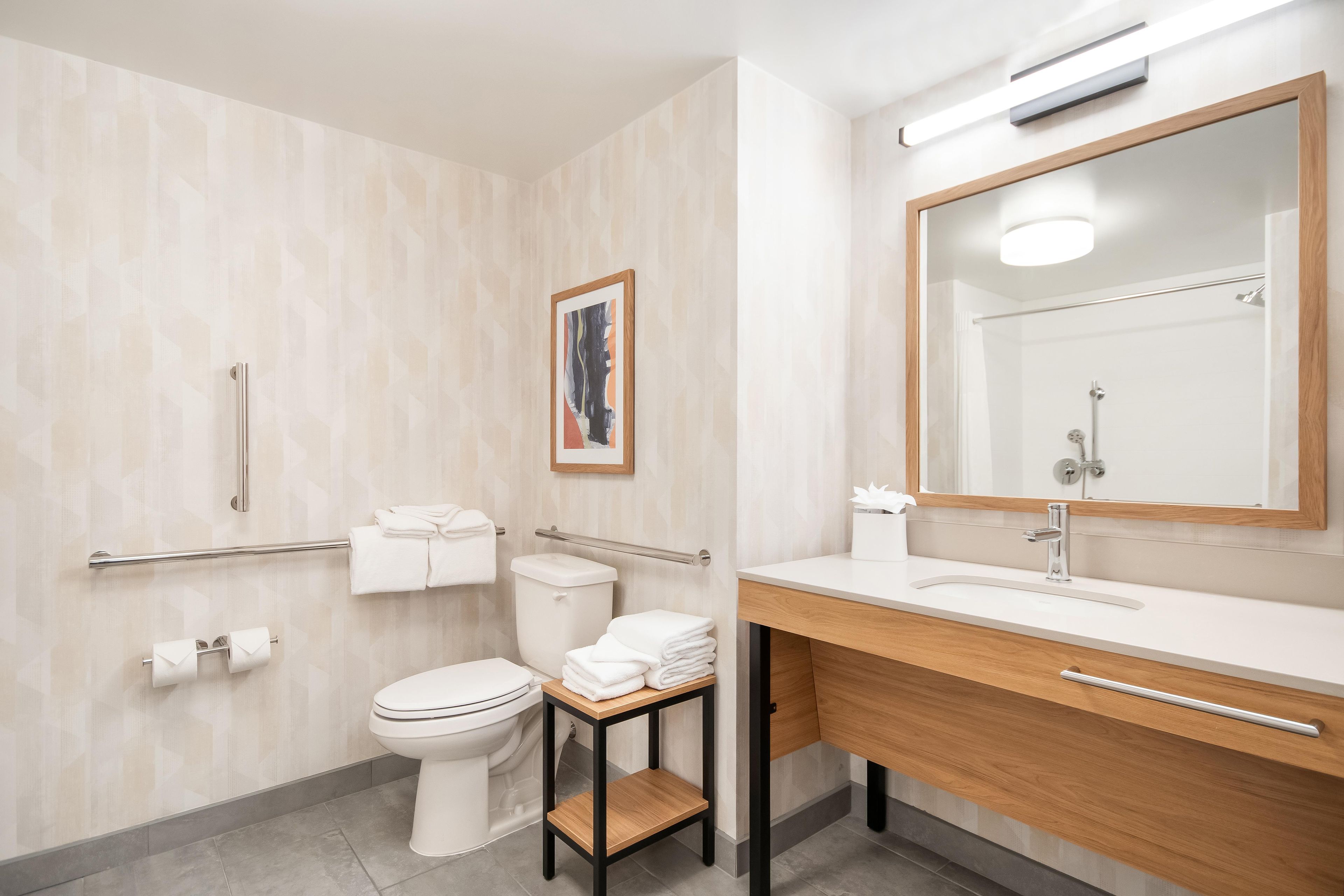 A modern bathroom with a toilet, sink, and a mirror.