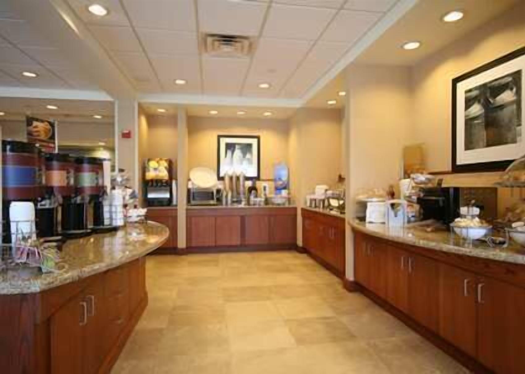 A modern kitchen with granite countertops, wooden cabinets, and a central island.