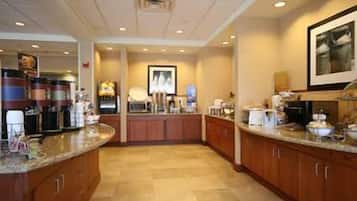 A modern kitchen with granite countertops, wooden cabinets, and a central island.