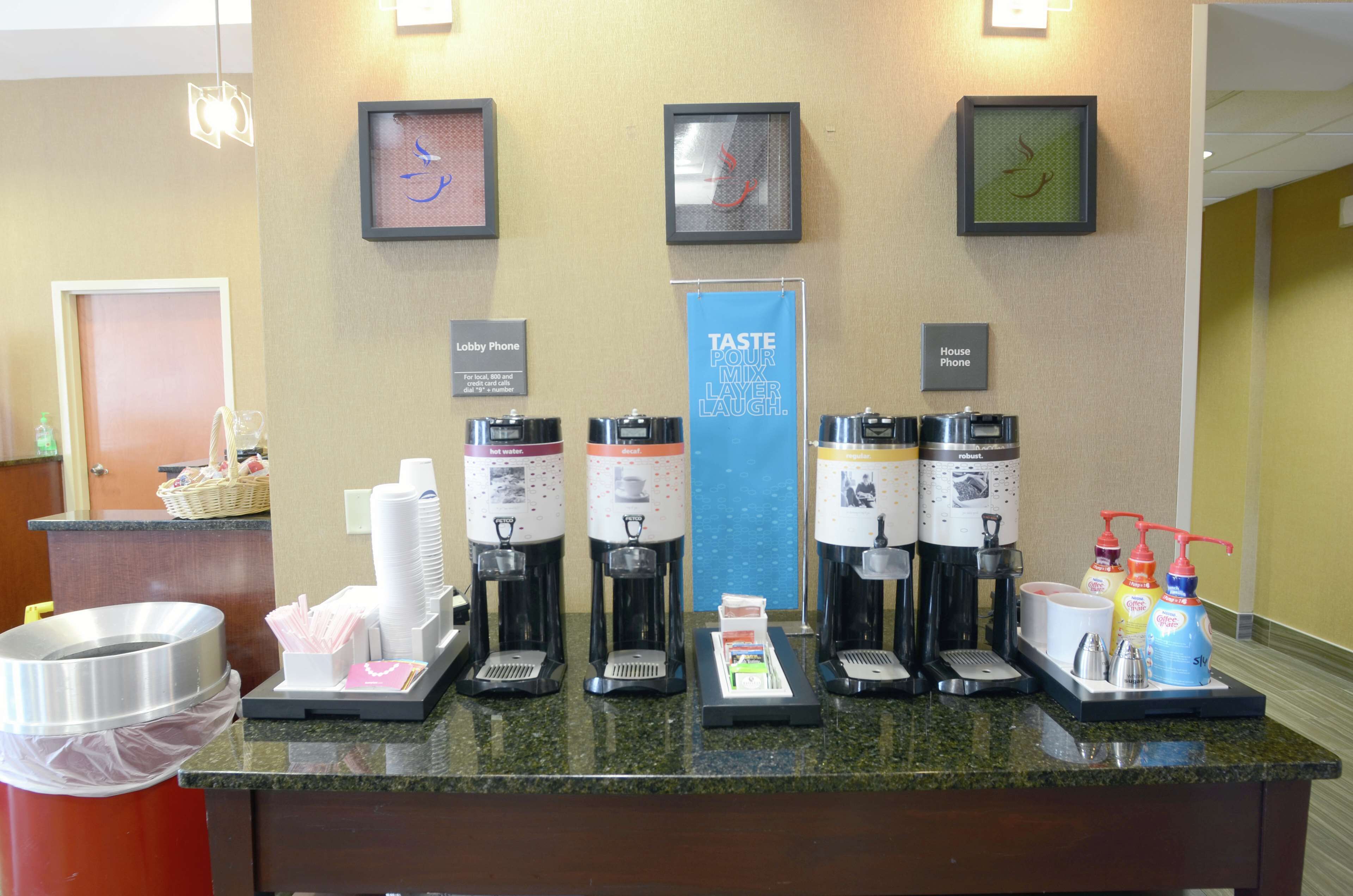 Una estación de café con varias máquinas de café y un letrero que dice "TASTE POUR MIX LAUGH".