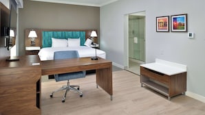A hotel room with a bed, desk, and a small bathroom area. - Hampton Inn & Suites Greenville (Greenville)