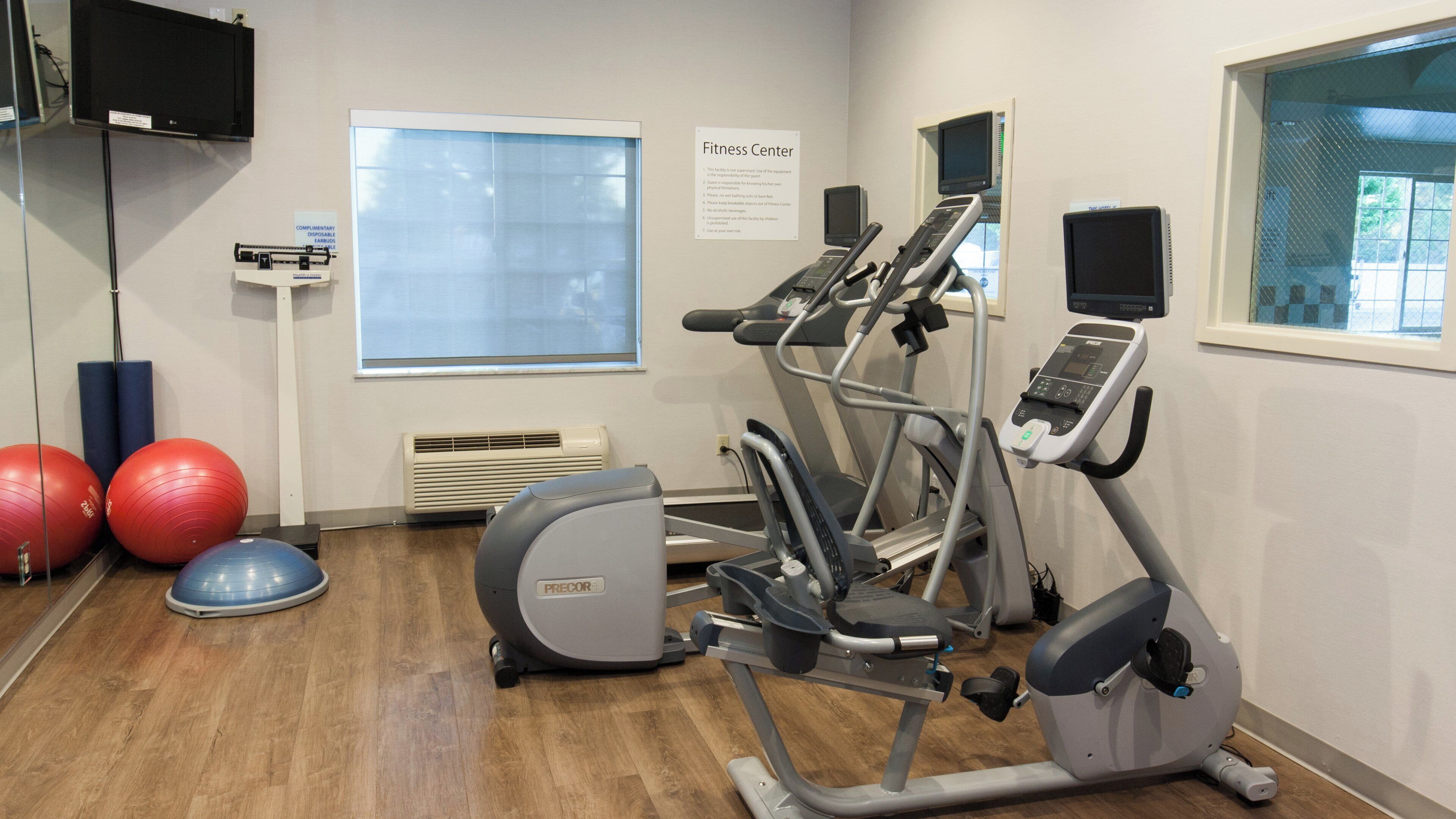 Un gimnasio con equipo de ejercicio, una cinta de correr y una bicicleta estática.