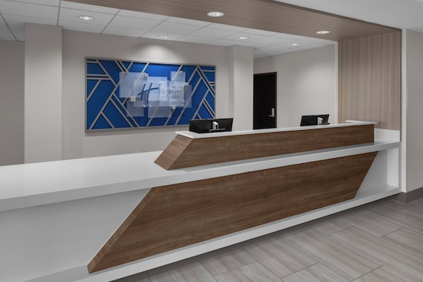 A reception desk with a modern design, featuring a white counter and wooden accents.