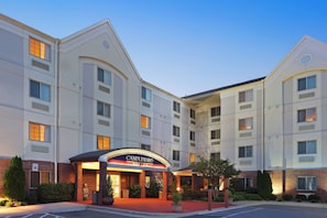 A multi-story hotel with a prominent entrance labeled 'CANDLEWOOD SUITES.'