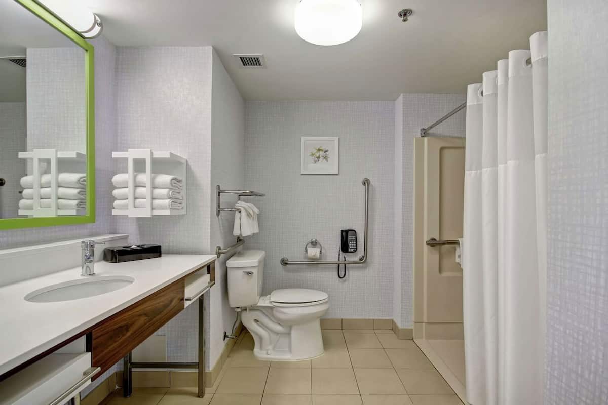 Un baño moderno con lavamanos, inodoro y zona de ducha.