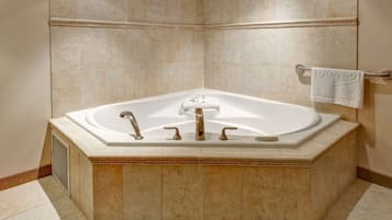 A large, freestanding bathtub with a towel rack above it.