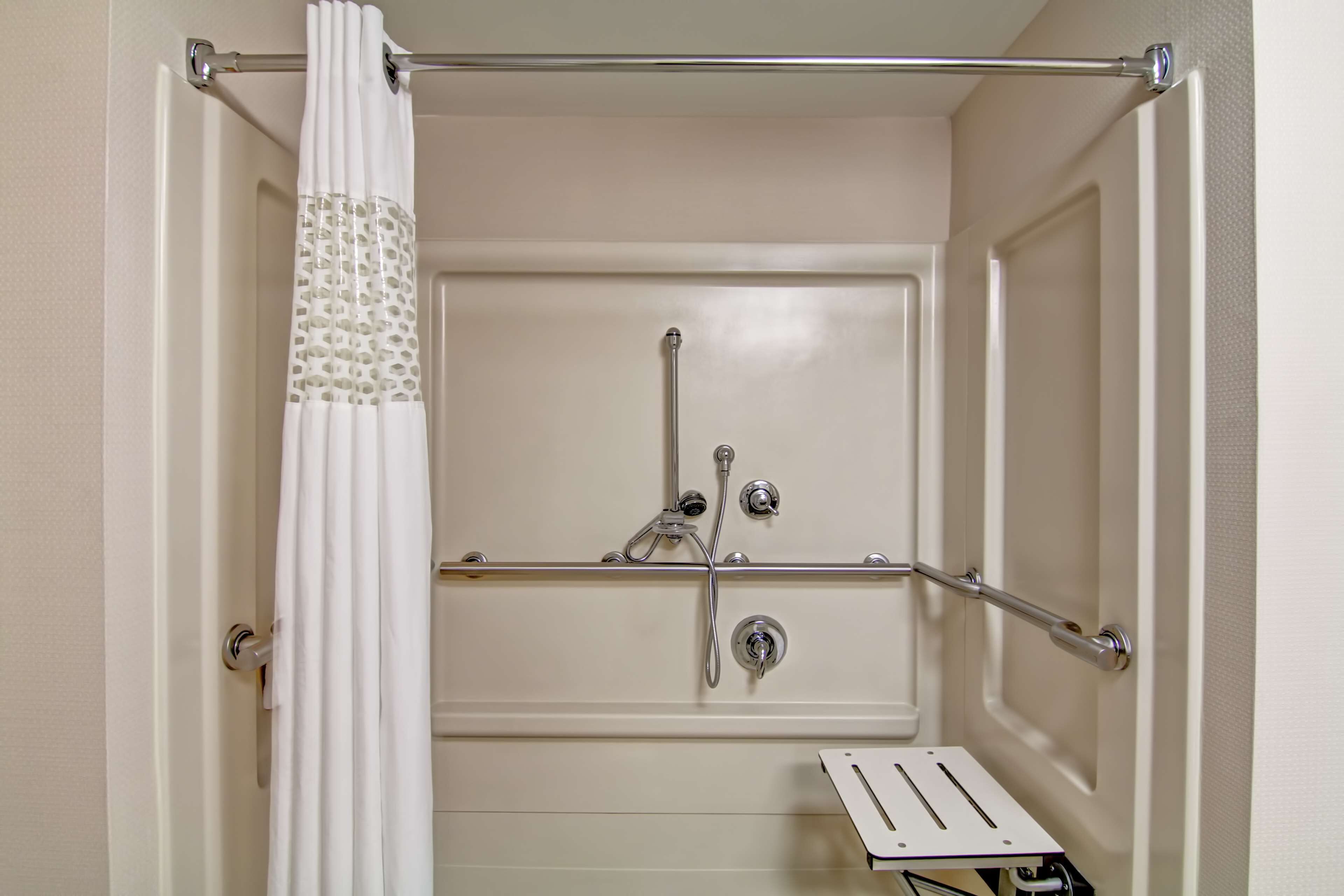 A bathroom with a shower, a towel rack, and a toilet.