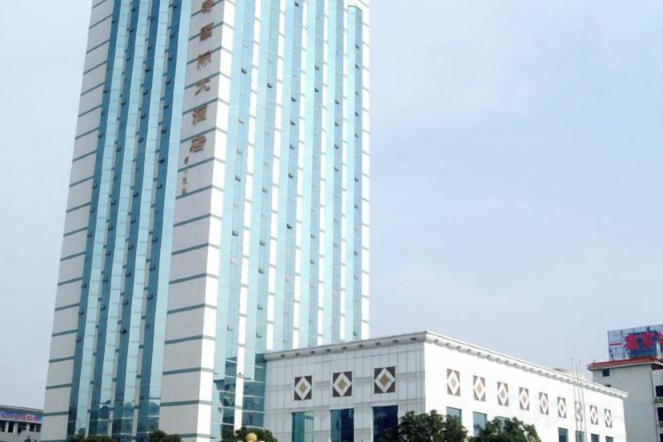 A tall building with a modern design, featuring a series of vertical lines and a patterned facade.