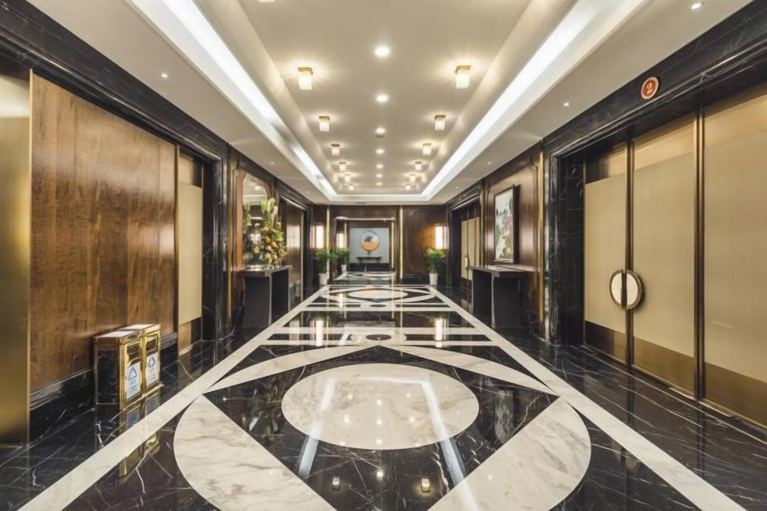 Un pasillo de hotel con suelo de mármol pulido, paneles de madera y un diseño circular central.