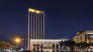 A high-rise building with a modern design, featuring a prominent vertical structure and a series of windows.