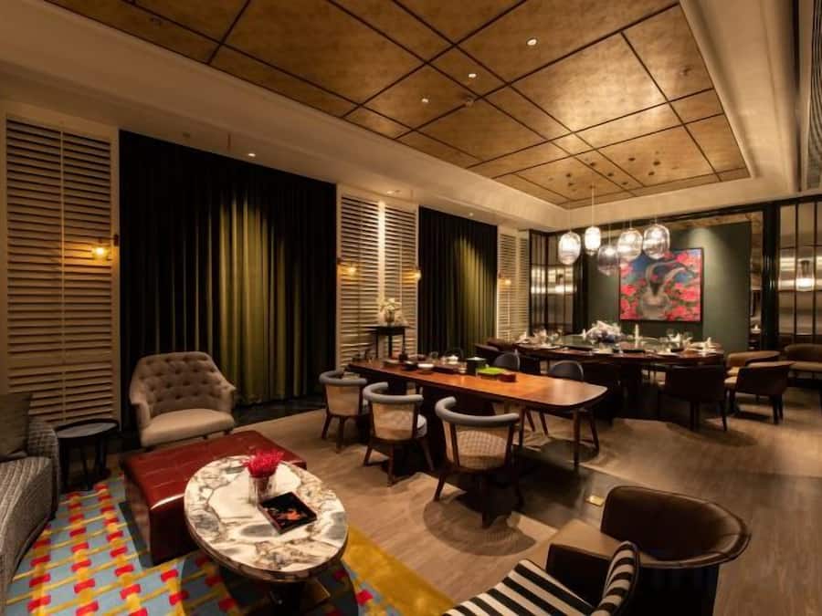 A modern interior with a dining area, seating, and a large artwork on the wall.