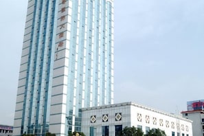 A tall building with a modern design, featuring a grid of windows and a white facade.