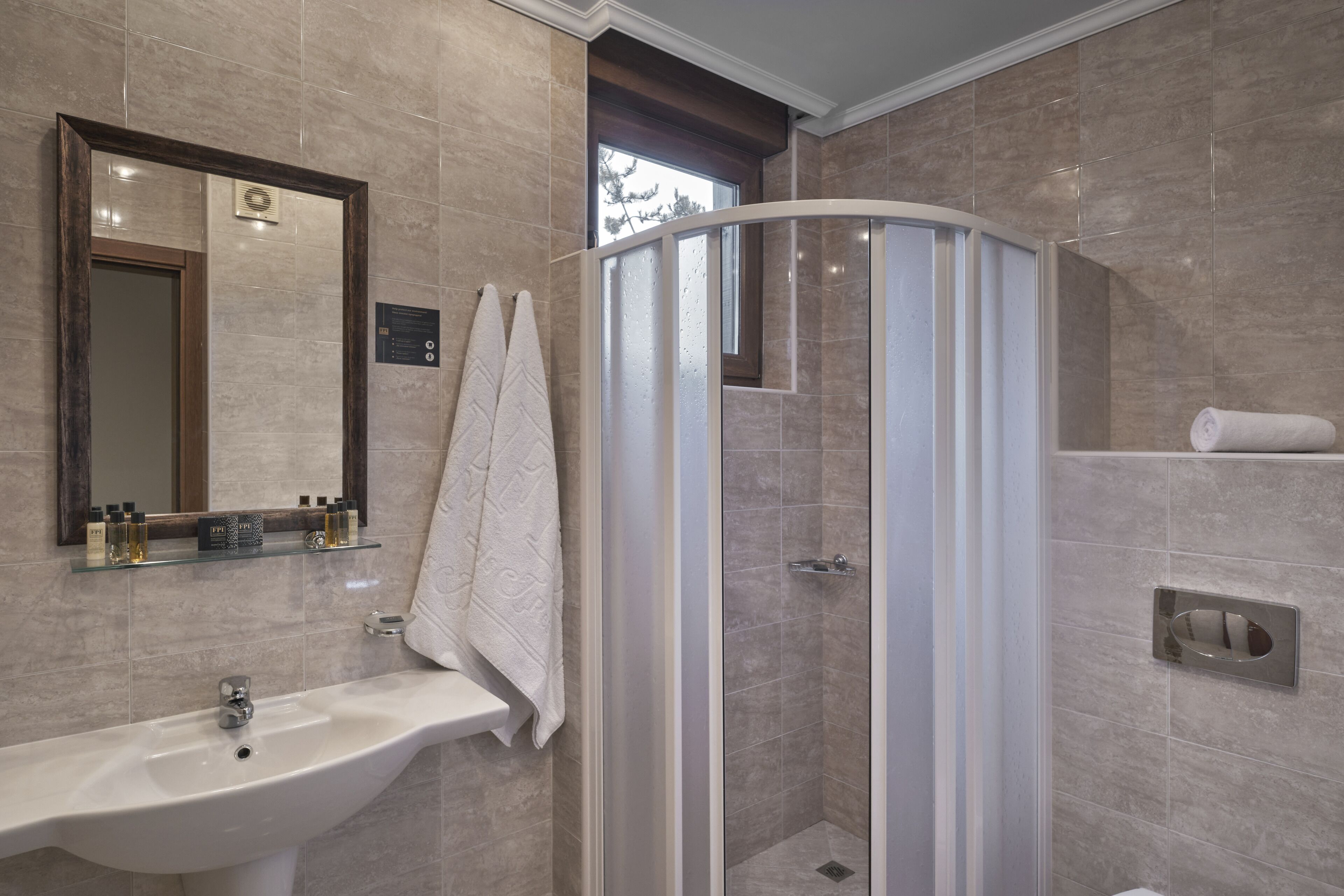 A bathroom with a sink, mirror, towel rack, and shower enclosure.