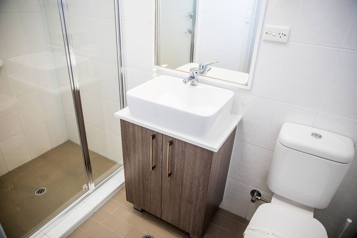 Baño con ducha, lavabo e inodoro.