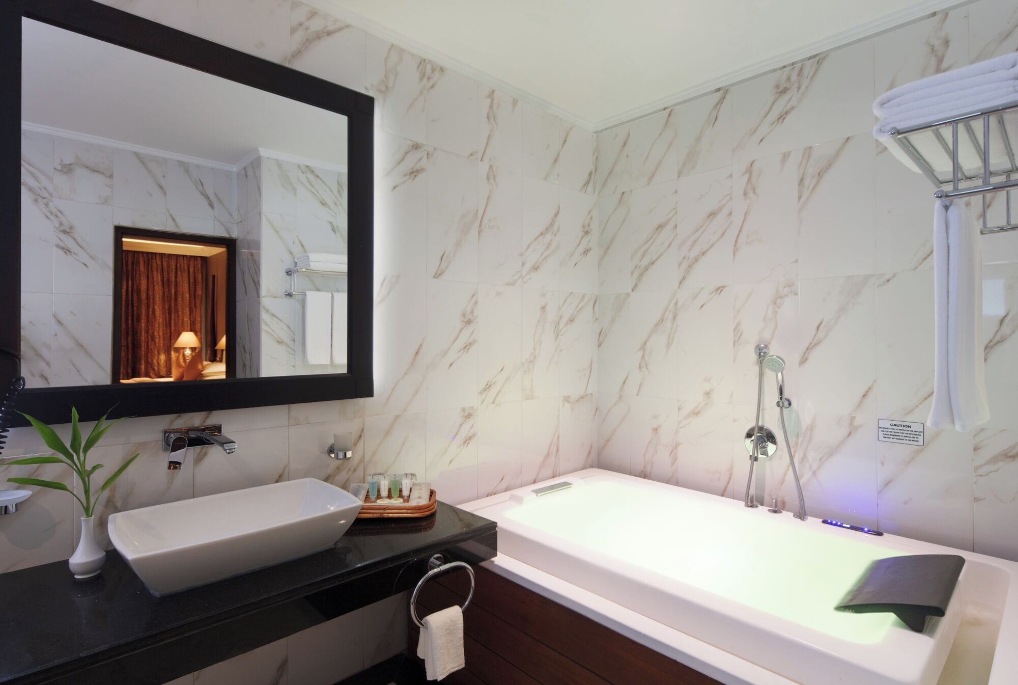 A bathroom with a large mirror, a white sink, a bathtub, and a shower.