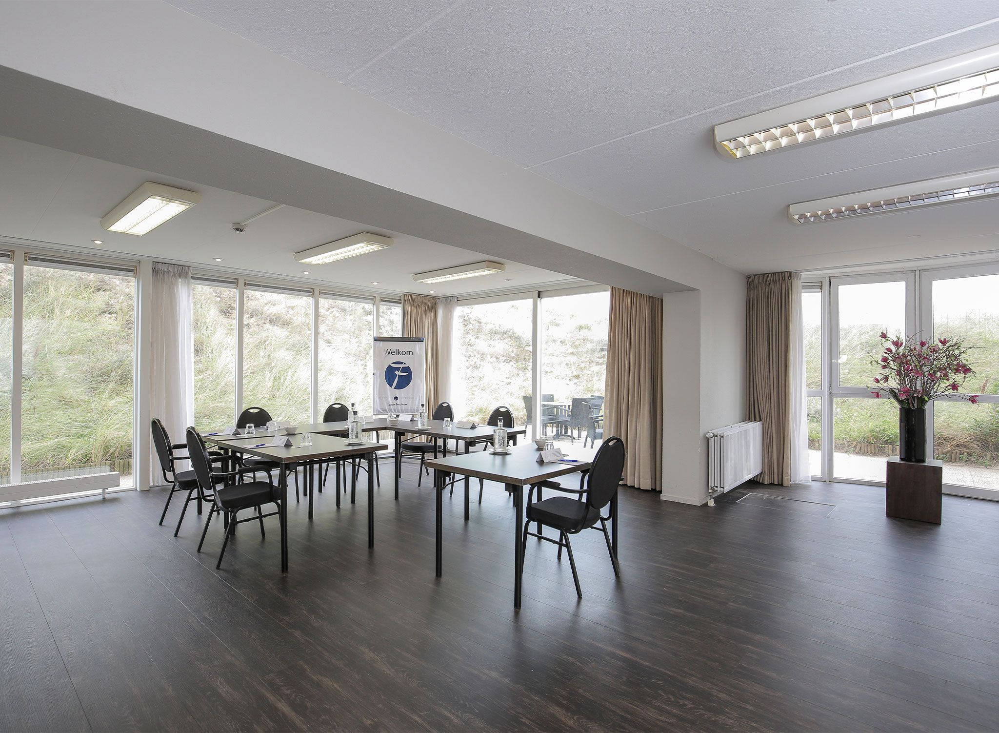 A conference room with a large table, chairs, and a banner.