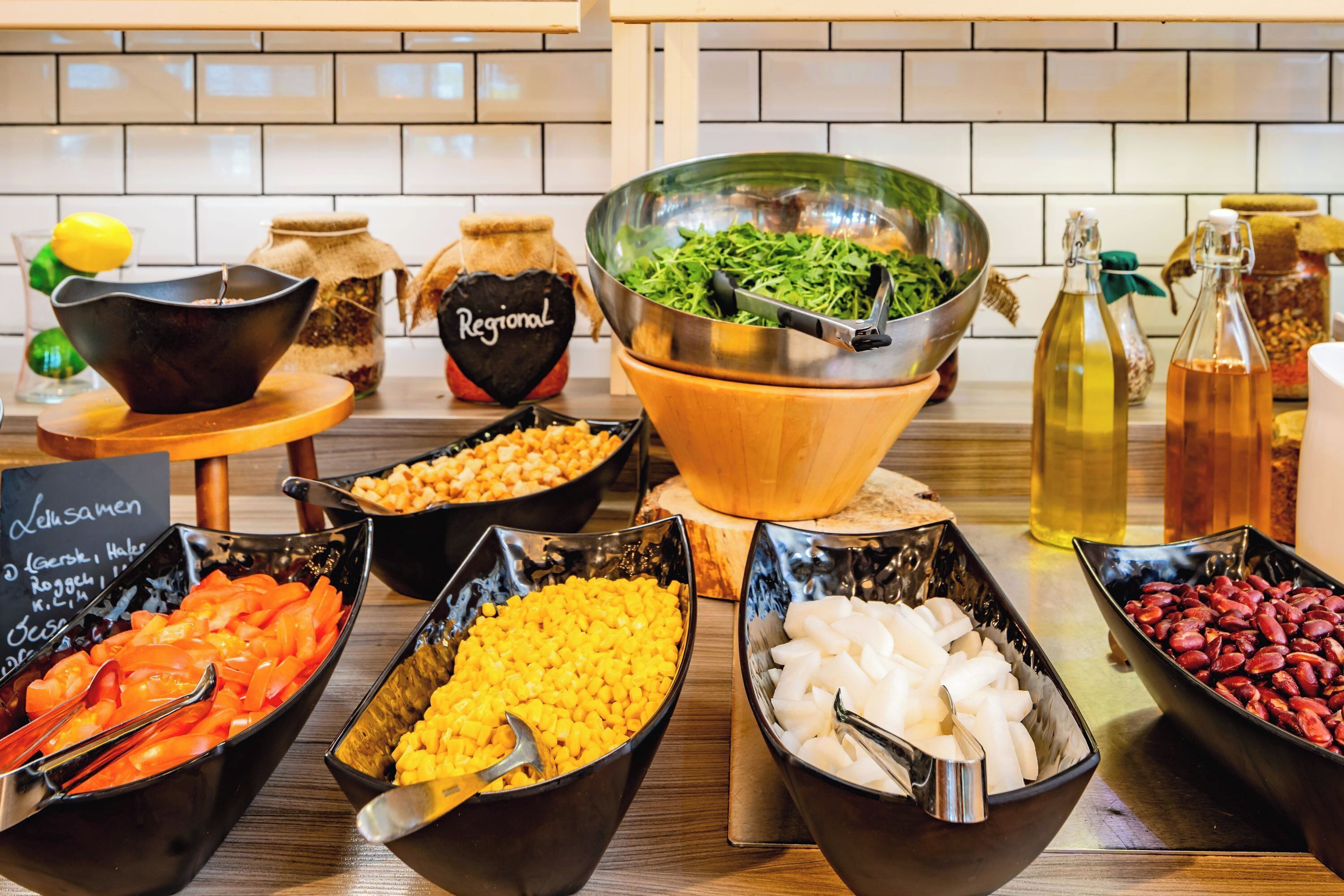 Un buffet proposant une variété de plats, notamment des légumes, des haricots et des salades.