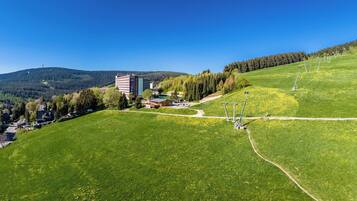 Un campo verde con un edificio y un telesilla.