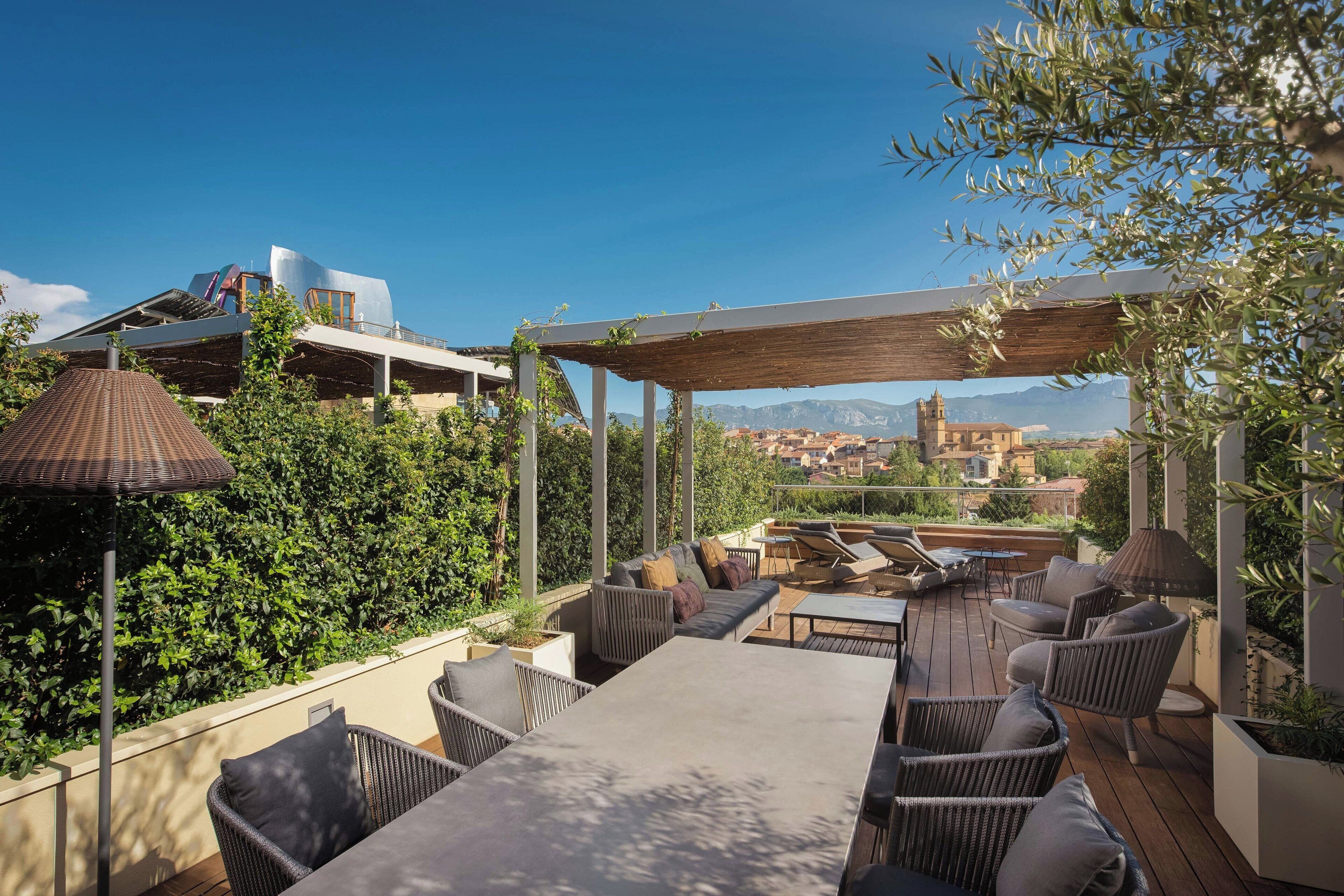 An outdoor patio with a dining table, chairs, and a pergola.