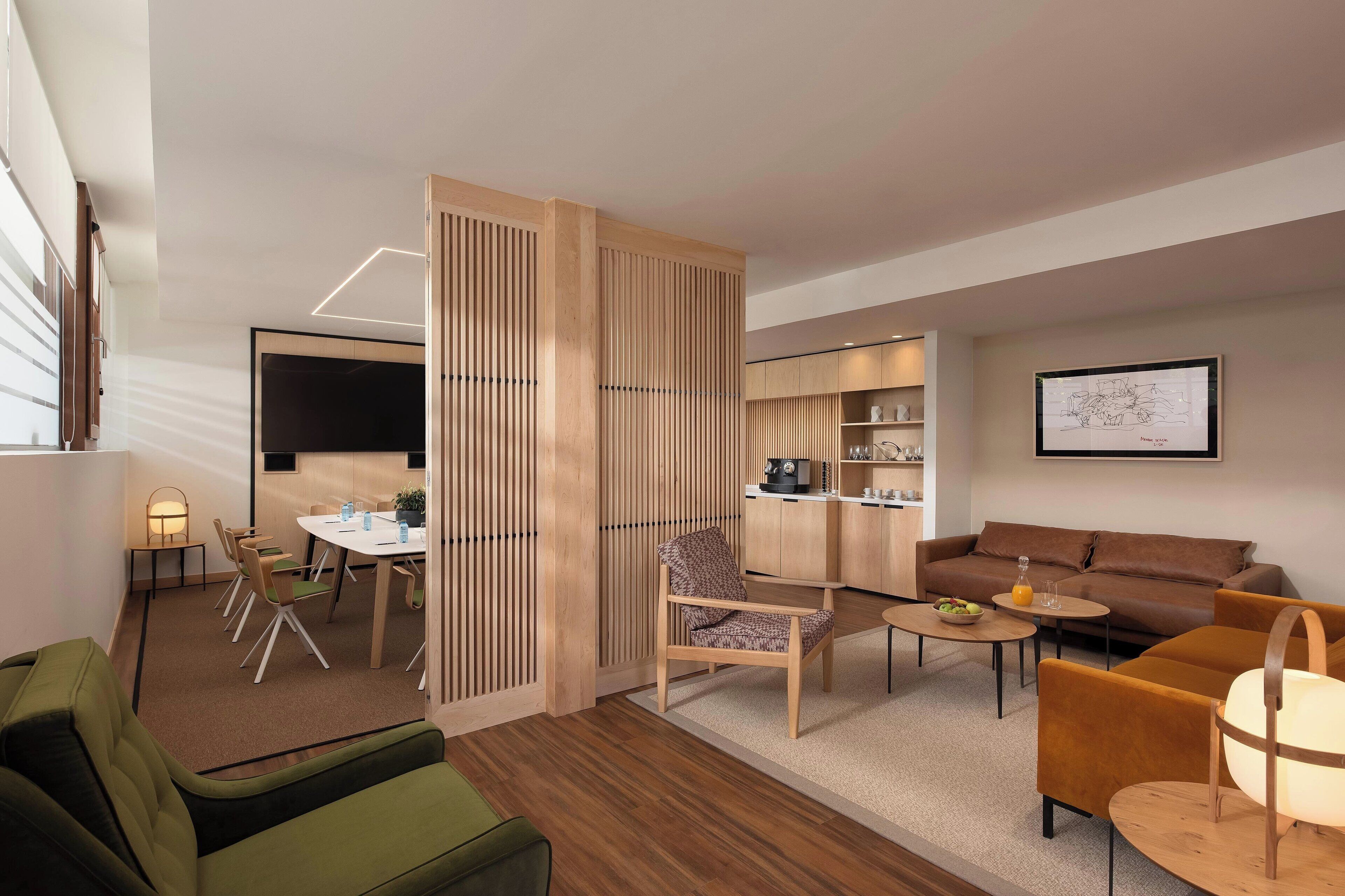 Uma sala de estar moderna com sofá, poltronas, mesa de centro e um espaço de jantar com cadeiras e mesa.