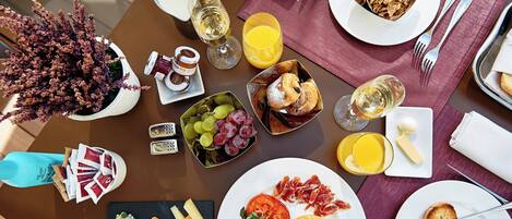 A breakfast setting with various food items, drinks, and a decorative plant.